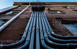 Electrical wires going up the side of a brick building